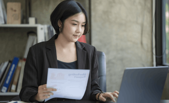 A native French linguist finalizes documents on a laptop, showcasing French Translation Services in Florida by native.
