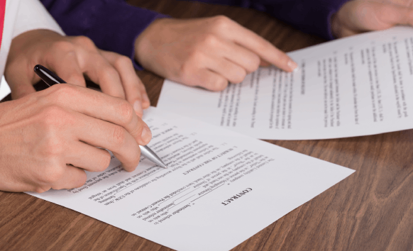 Translator review a legal contract at a Miami office, highlighting clauses for Translation Services in Miami.