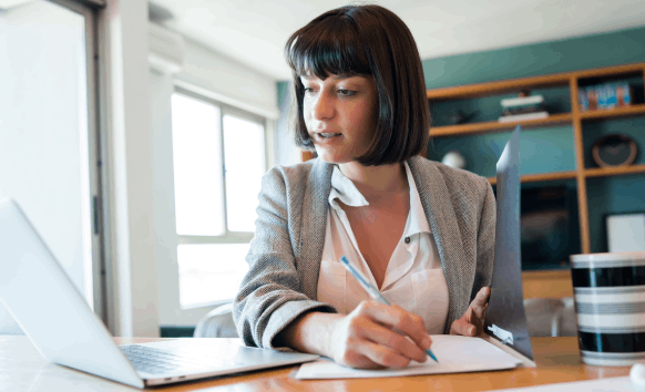 A translator reviews a bilingual business contract beside personal forms, highlighting Spanish Translation Services.